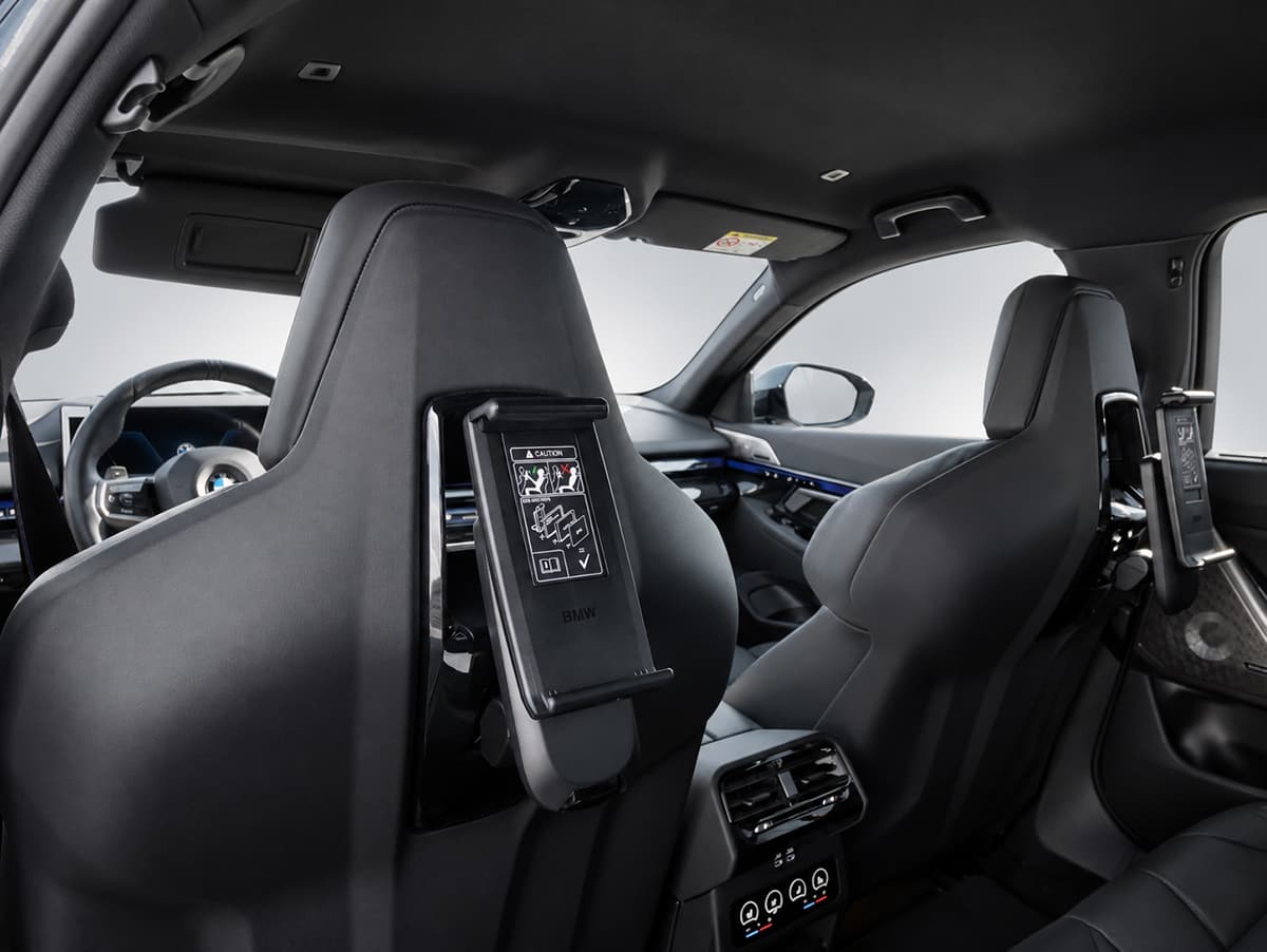 Interiorul BMW-ului, cu ecrane montate pe spătarele scaunelor din față și comenzi de climatizare pentru pasagerii din spate.